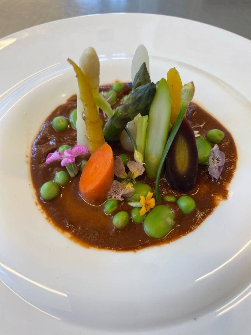 Spring vegetables with black garlic romesco, plated by private chef Jackson Locklear
